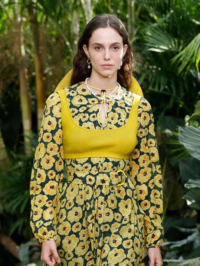 Model in a floral dress with a yellow bralette